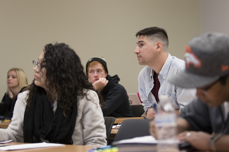 Five students in a classroom listening to a lecture.