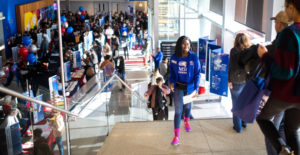Students walking up and down the stairs in a bustling JSB during an event.