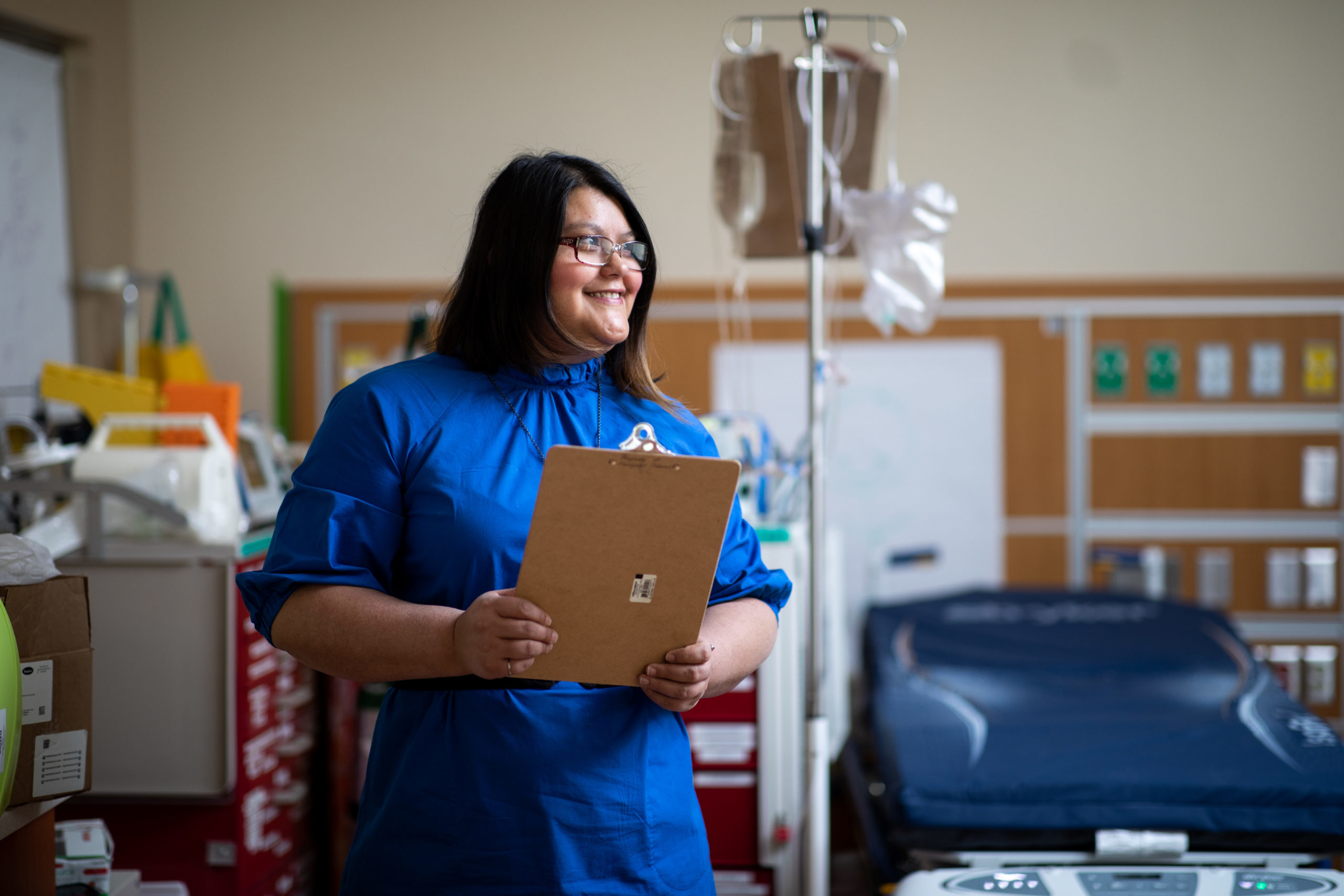 Person standing in medical office with clipboard