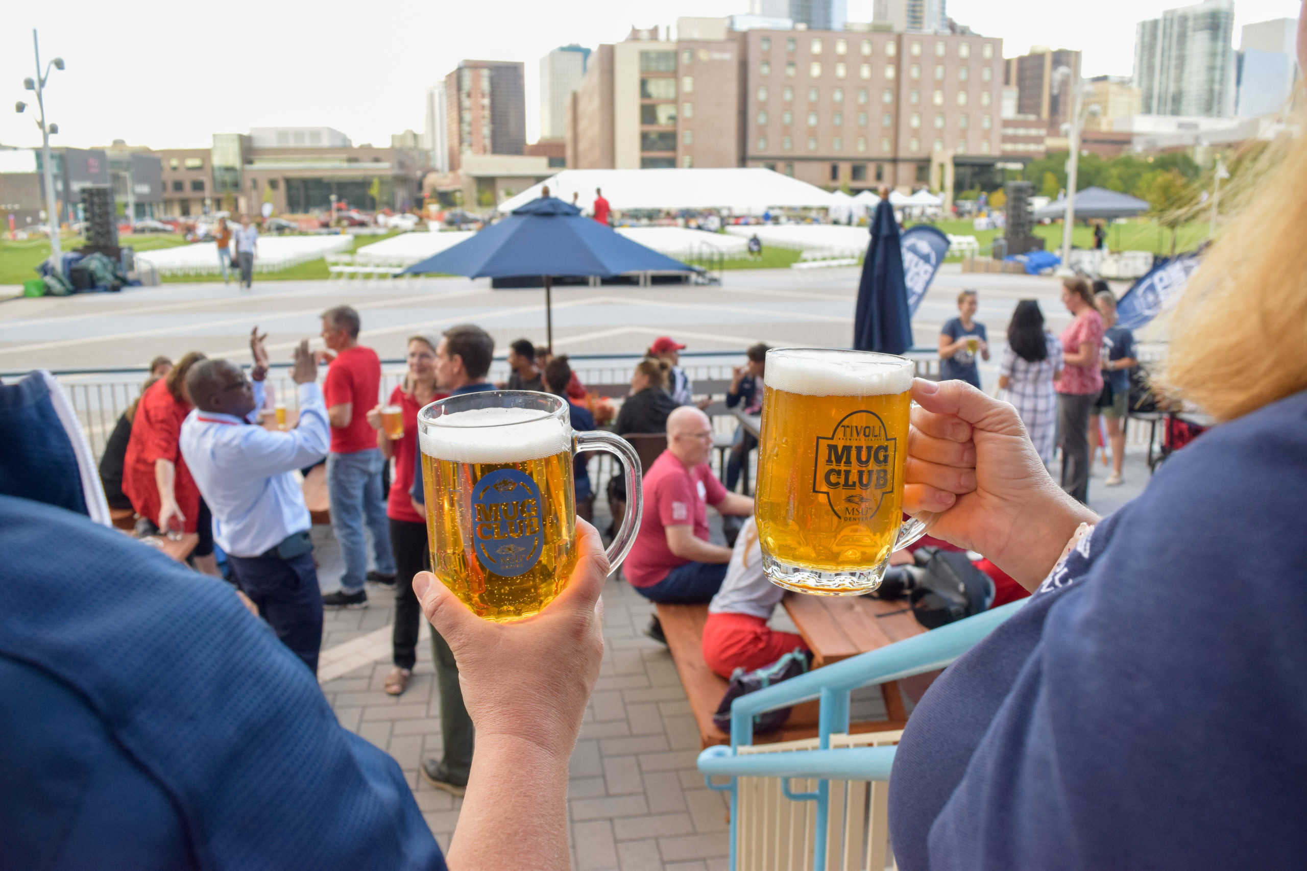 Two people cheersing two beer mugs at a Mug Club event at the Tivoli.