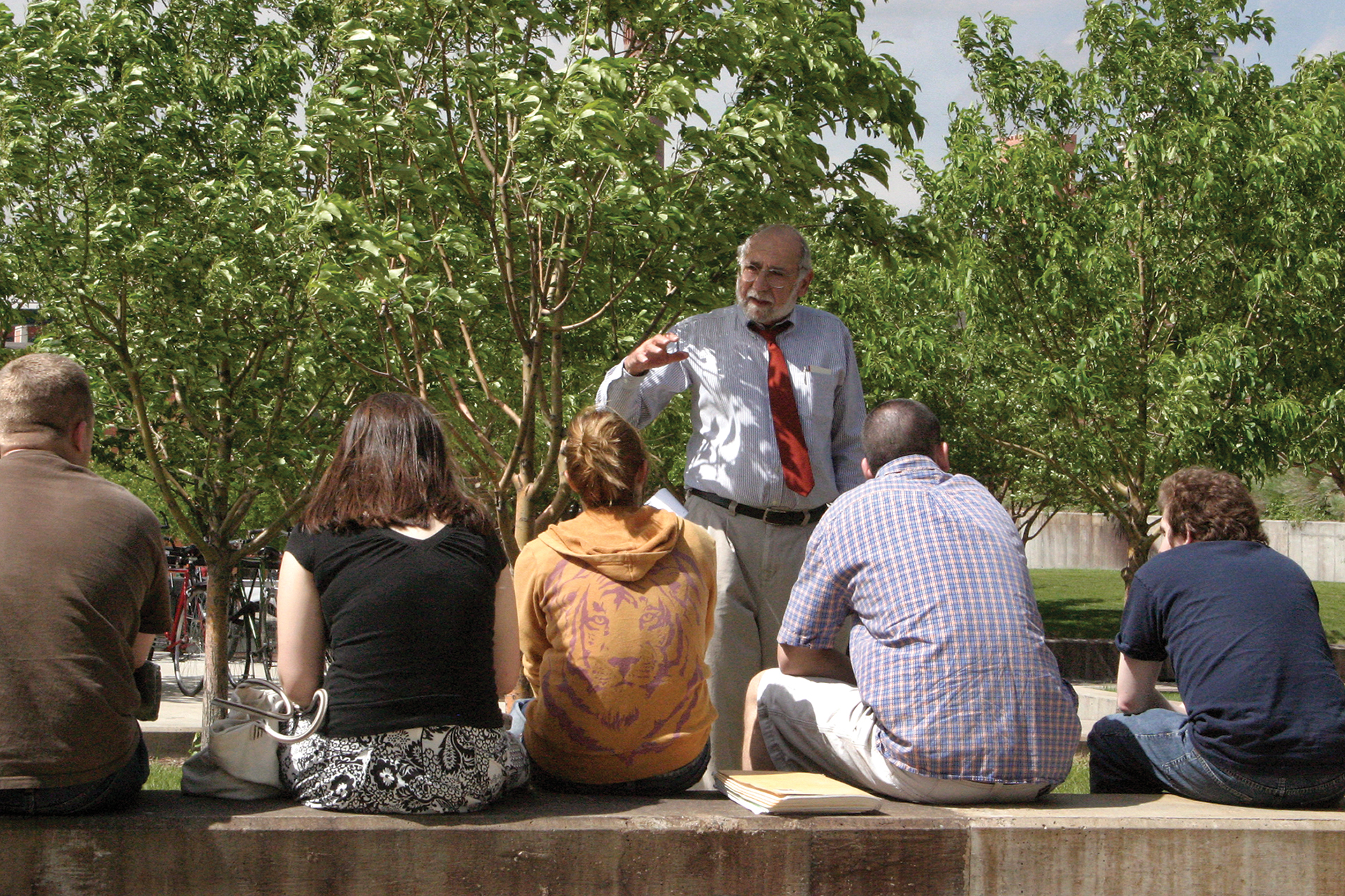 Older man teaching a small class in an outside setting