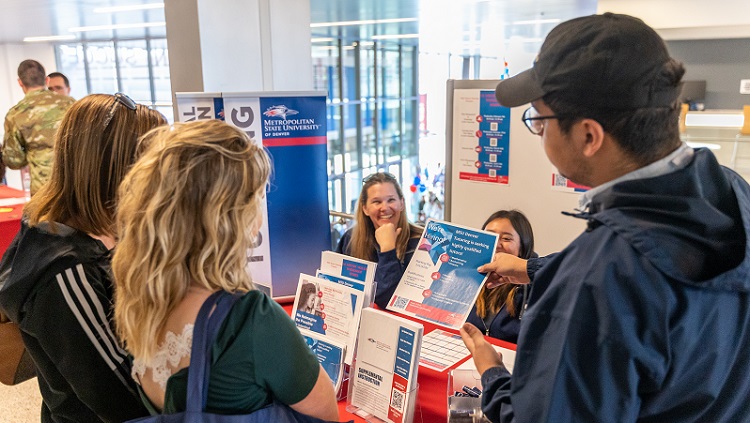 MSU Denver employee speaking with Open House attendees.