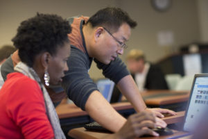 Dr. Hsin-Te Yeh working with a student of African-American descent at a computer.