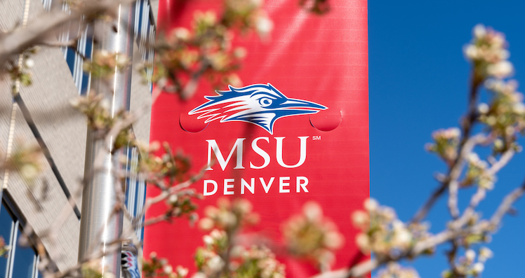 MSU Denver banner in red with leaves in forefront. en español: Bandera de MSU Denver en rojo con hojas en primer plano.