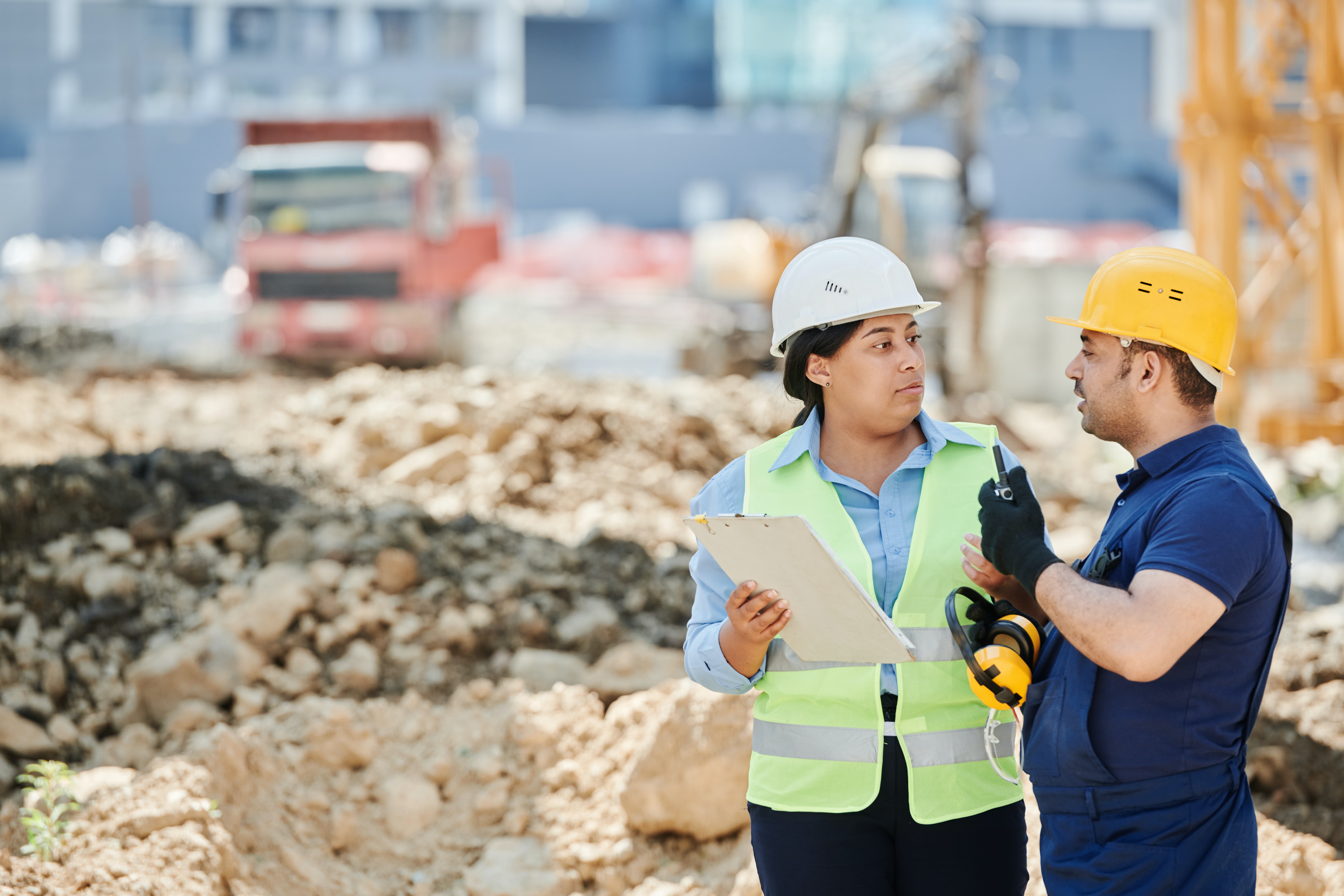 A Man and Woman Wearing Hard Hat While Talking