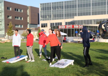 Young alumni playing cornhole in front of the Student Success Building at the 2021 Roadrunners 5K.