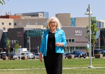 Barb Grogan standing near the Tivoli with the SpringHill Suites in the background