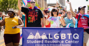People marching in a Pride march wearing MSU Denver swag and holding an 