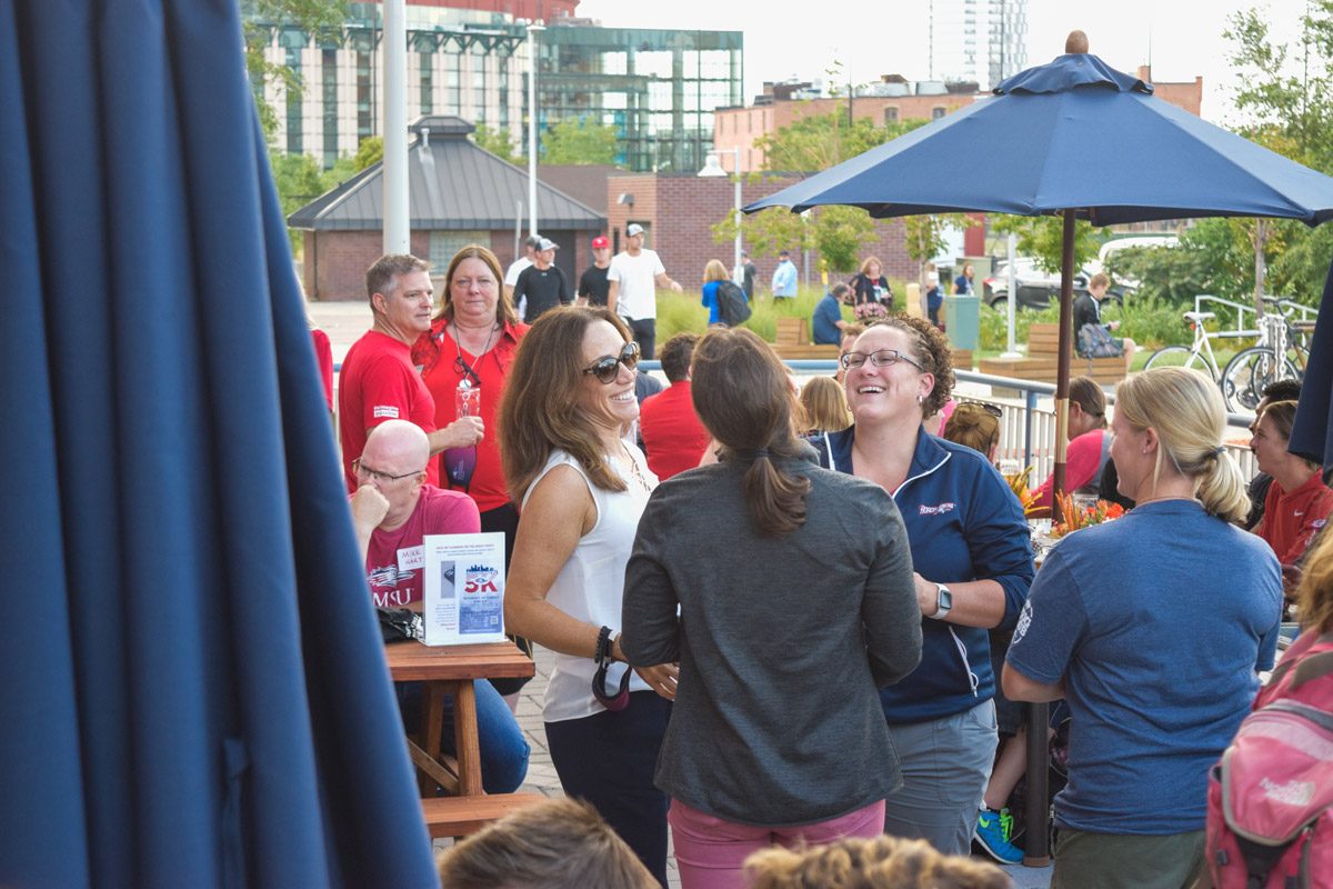 A group of people laughing at an event at the Tivoli Brewing Co. Tap House