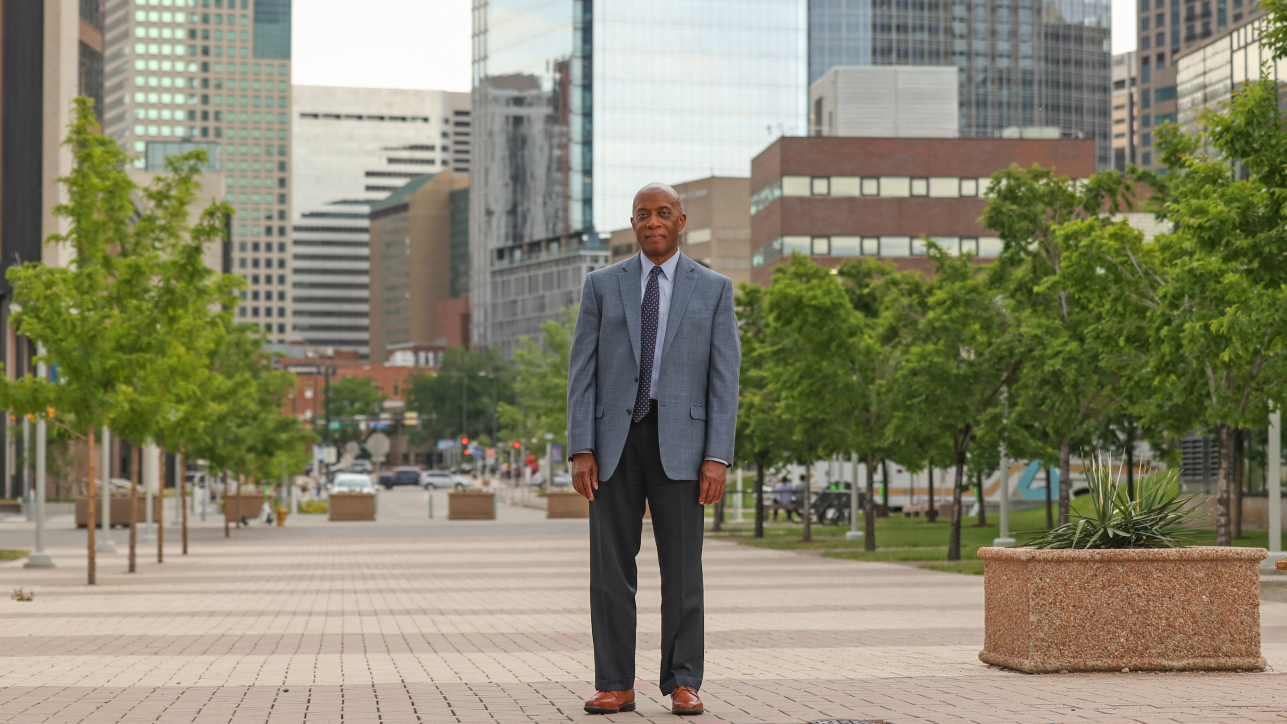 Russell Noles standing near the Auraria Events Center with downtown Denver in the background