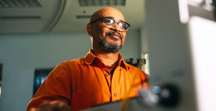 Stock images of person in orange shirt typing on a computer.