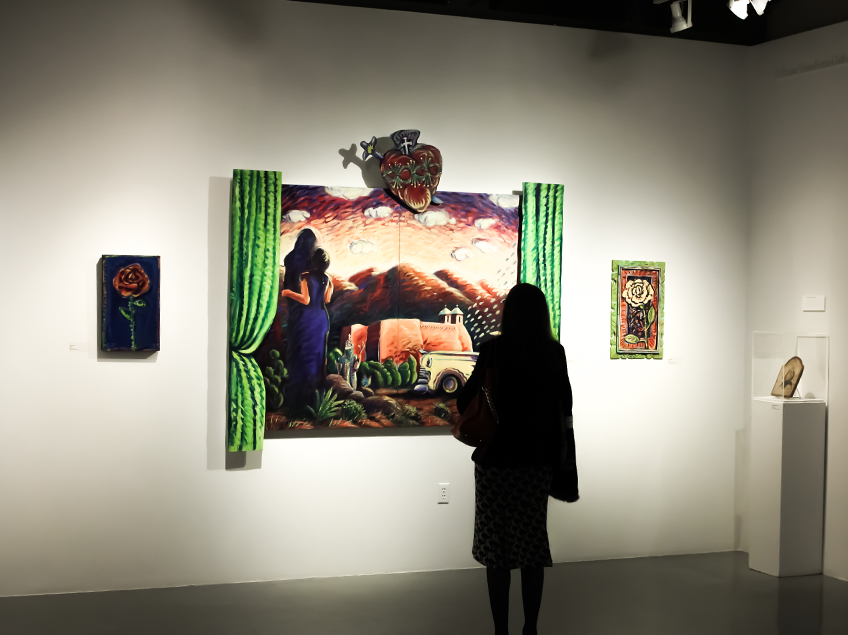 Person viewing colorful paintings in an art gallery.