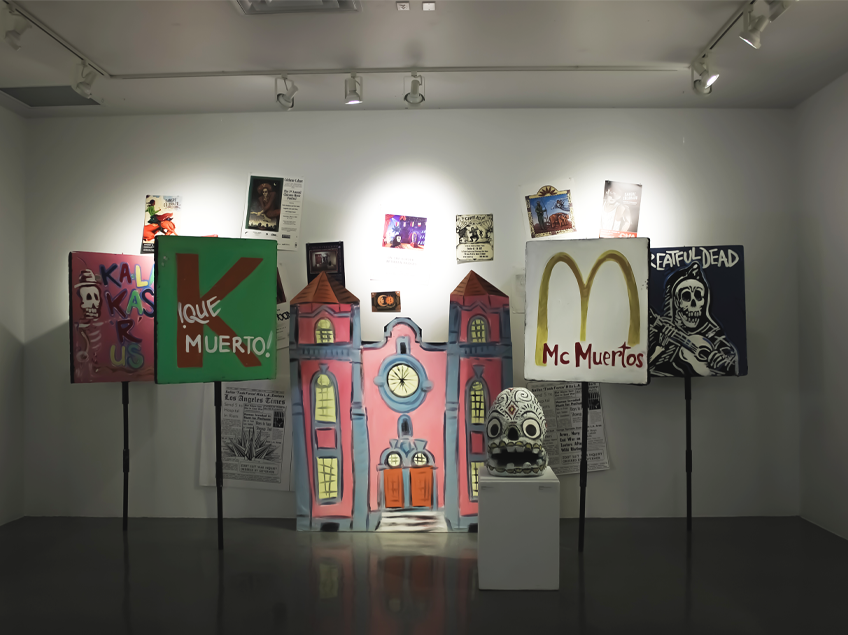 Exhibition space with colorful artworks, including skeleton-themed canvases and a pink building mural.
