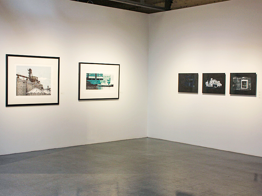 Art gallery wall with five framed artworks, including industrial and harbor scenes.