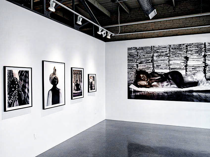 Gallery with framed black-and-white photographs on white walls.