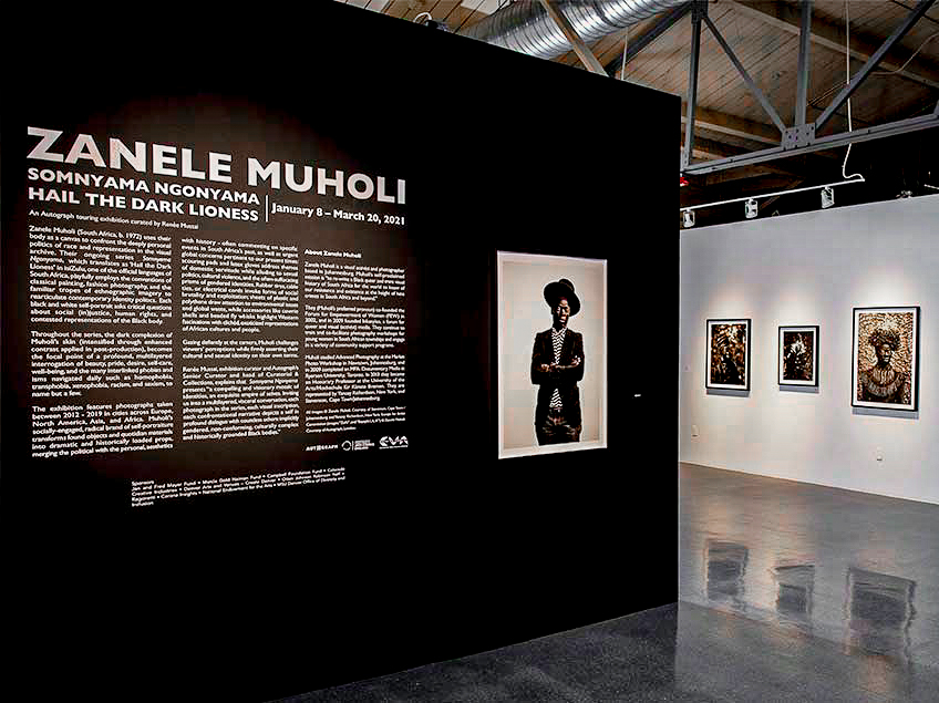 Art gallery walls with exhibition text and black and white photos.