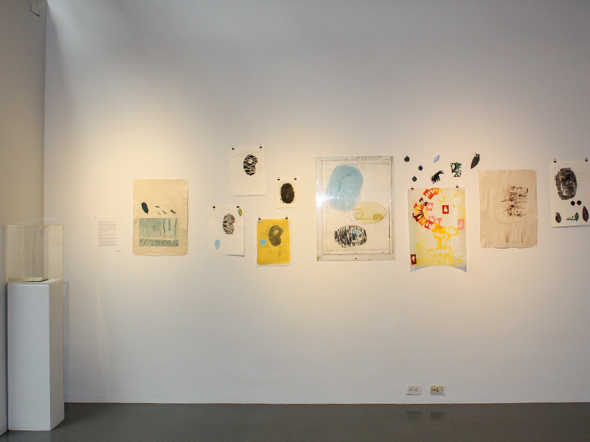 A gallery wall showcasing abstract artworks with shapes and colors like black, blue, yellow, and red.