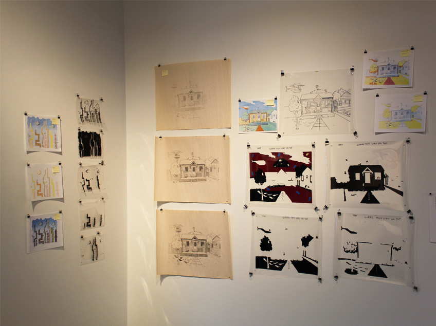 Art display of sketches and paintings on two walls, featuring abstract and architectural themes.