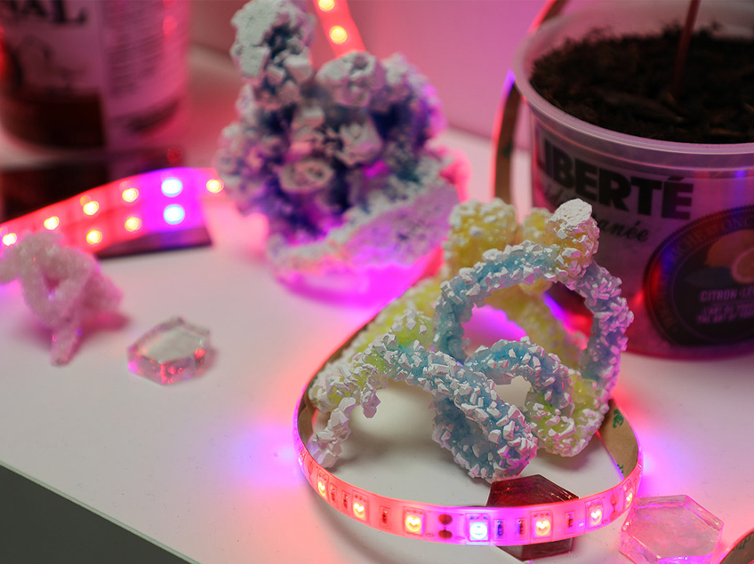Colorful crystal like sculptures and LED strip lights on a tabletop.