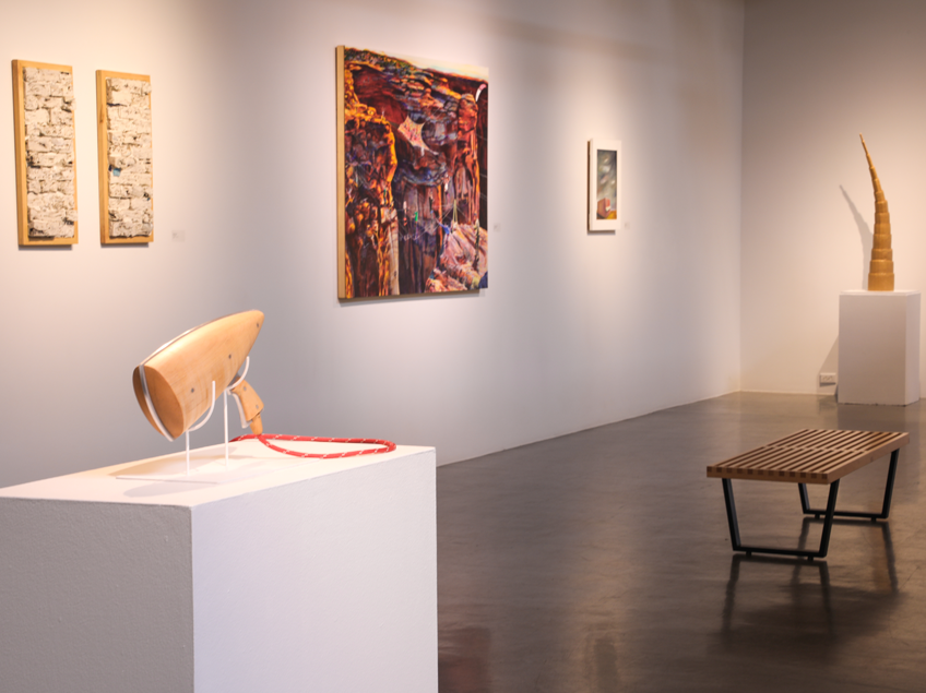 An art gallery featuring sculptures and paintings on display.