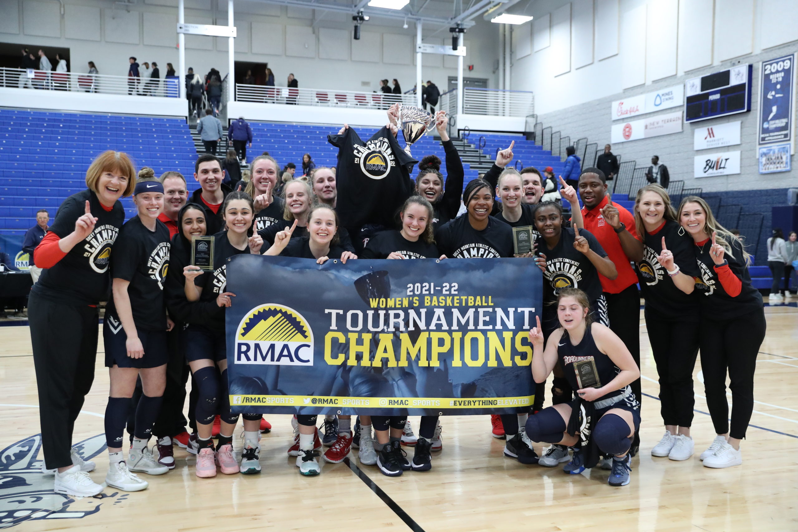 Roadrunners women's basketball team with the RMAC Championship banner after the title game in 2022.