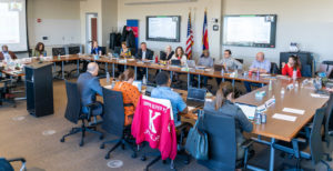 MSU Denver Board of Trustees members sit at desks in a rectangle shape.