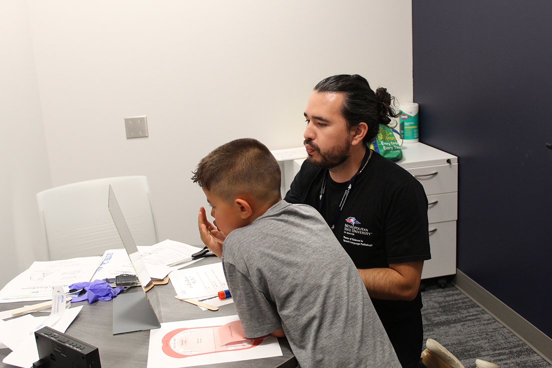 Graduate MS SLP student (right) working with elementary school aged child (left)