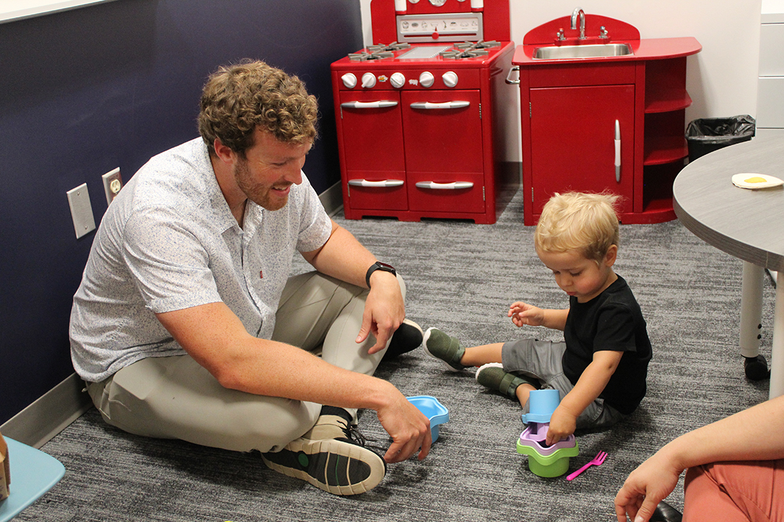 Graduate MS SLP student (left) working with toddler aged child (right)