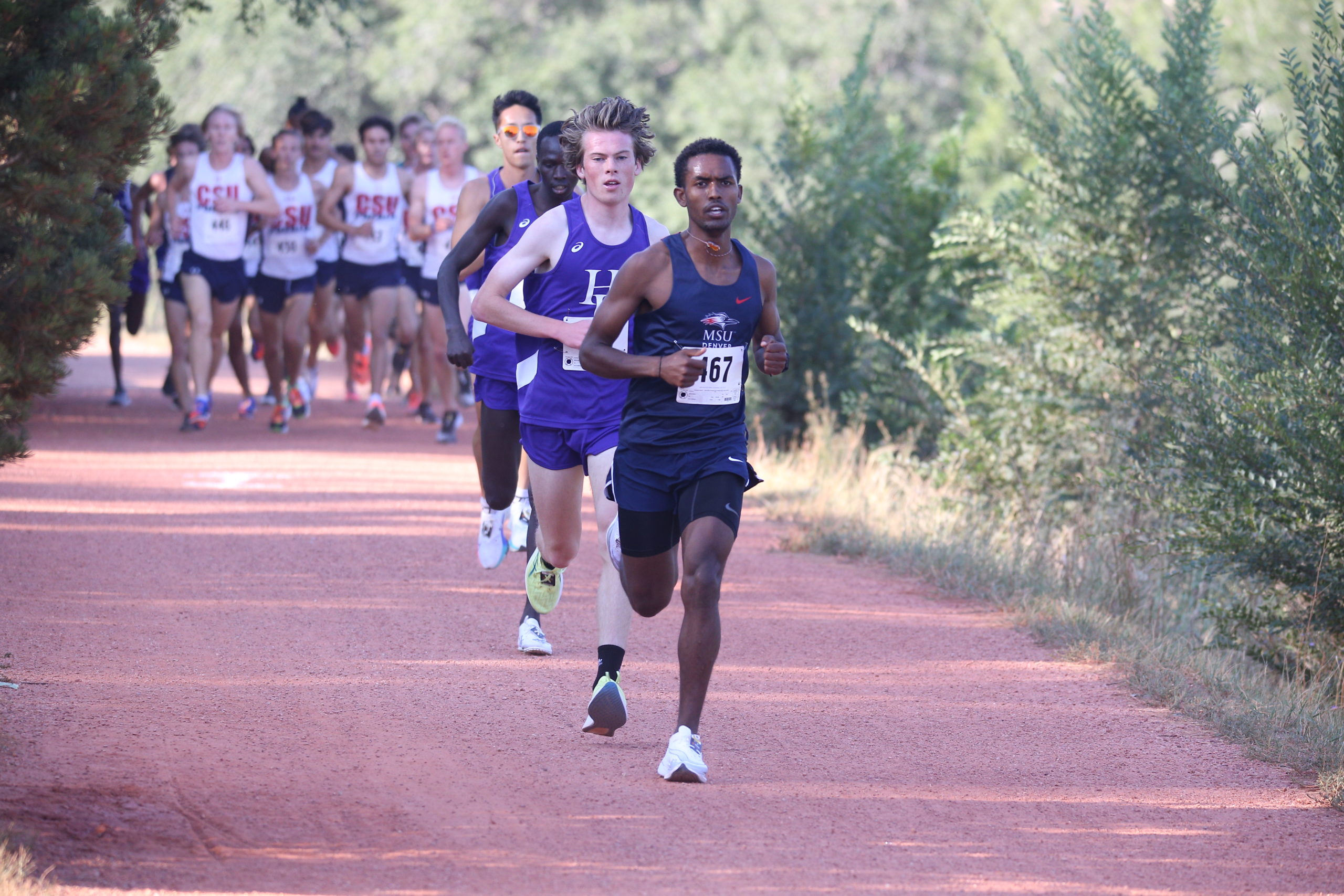 Men's cross country runner Yoni Kefle leads a large pack of runners at a race in 2021.