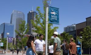 Students standng beneath MSU Denver pole banner