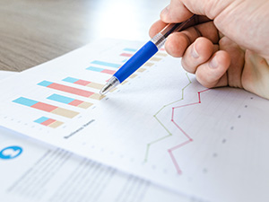 Data analyst parsing out data on paper