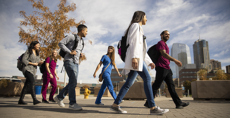 Six students walk across campus.