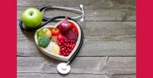 Fruit and vegetables in a hear-shaped pan surrounded by a stethoscope.