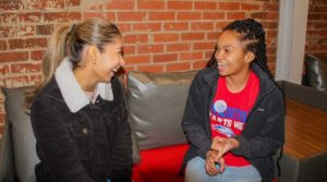 Student and peer mentor sitting together on a couch.