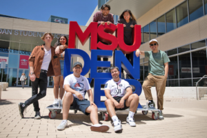 Students posing around MSU Denver sign outside JSSB
