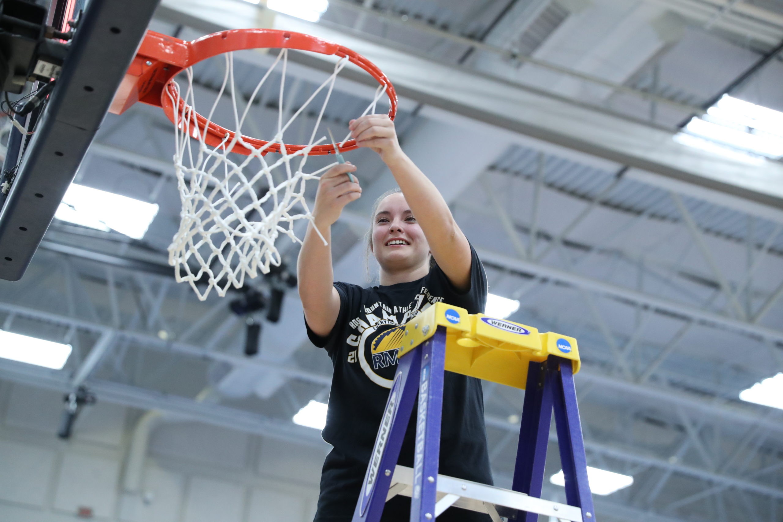 Women's basketball player Brianna Bailey cutting down the nets after MSU Denver's 2022 RMAC championship