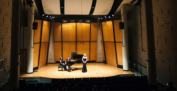 Singer and pianist performing in recital hall