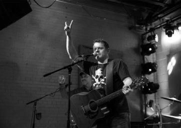 matthew campbell playing guitar and singing on stage in a band