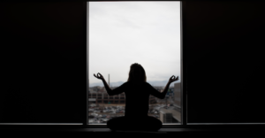 Silhouette of person meditating.