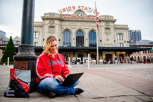 An MSU Denver student studies on her laptop outside of Union Station.