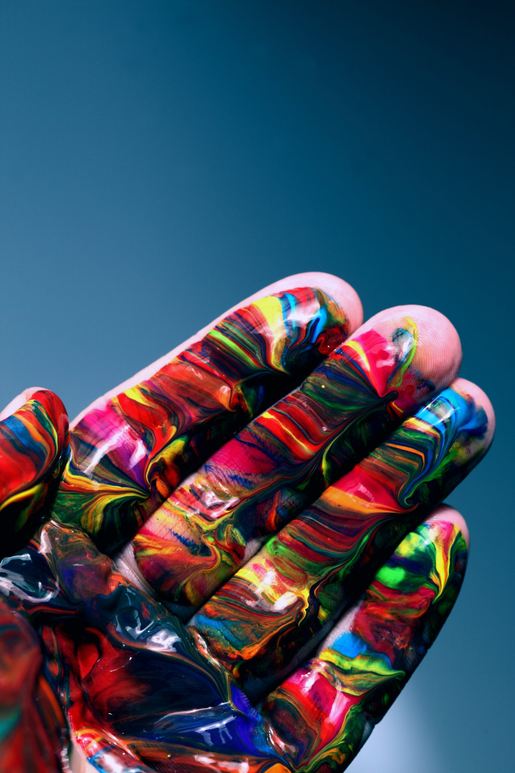 A hand with colorful paint on the fingers and palm