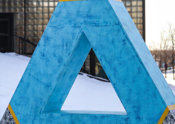 blue 3d triangle with a a triangle hole and black/white paisley corners