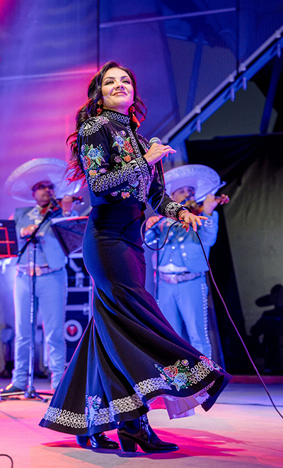 Lupita Infante performing on pink and purple stage