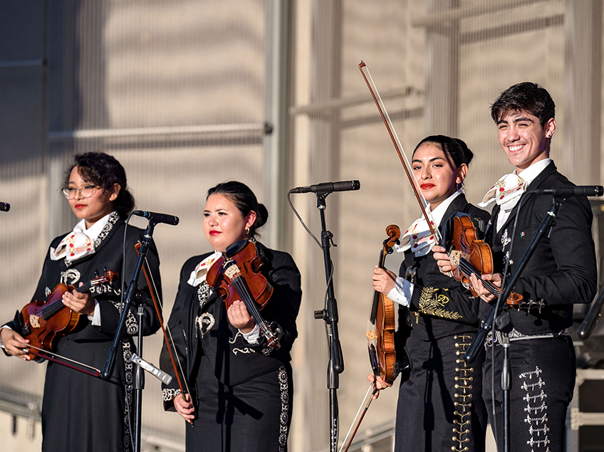 Four mariachi players on a stage