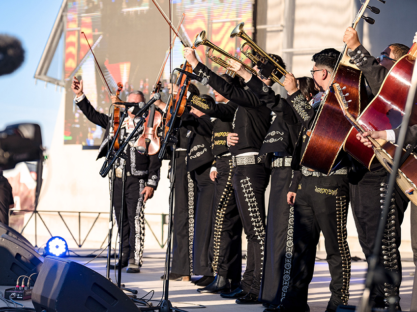 mariachi performers holding up their instruments in a line