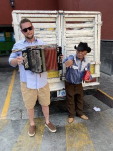 Travis Luther playing an accordion in Mexico