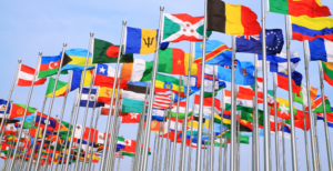 Flags from around the world flying on a pole.