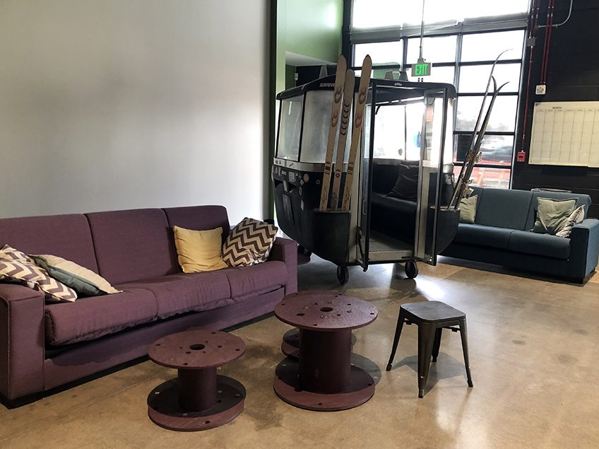a purple couch and ski gondola in a lounge with end tables