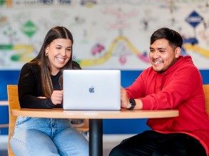 MSU Denver student Maria Dos Santos Oliveira, on the left, sits in front of a laptop with Alejandro Reyes complete his class schedule and finalize his transfer to MSU Denver