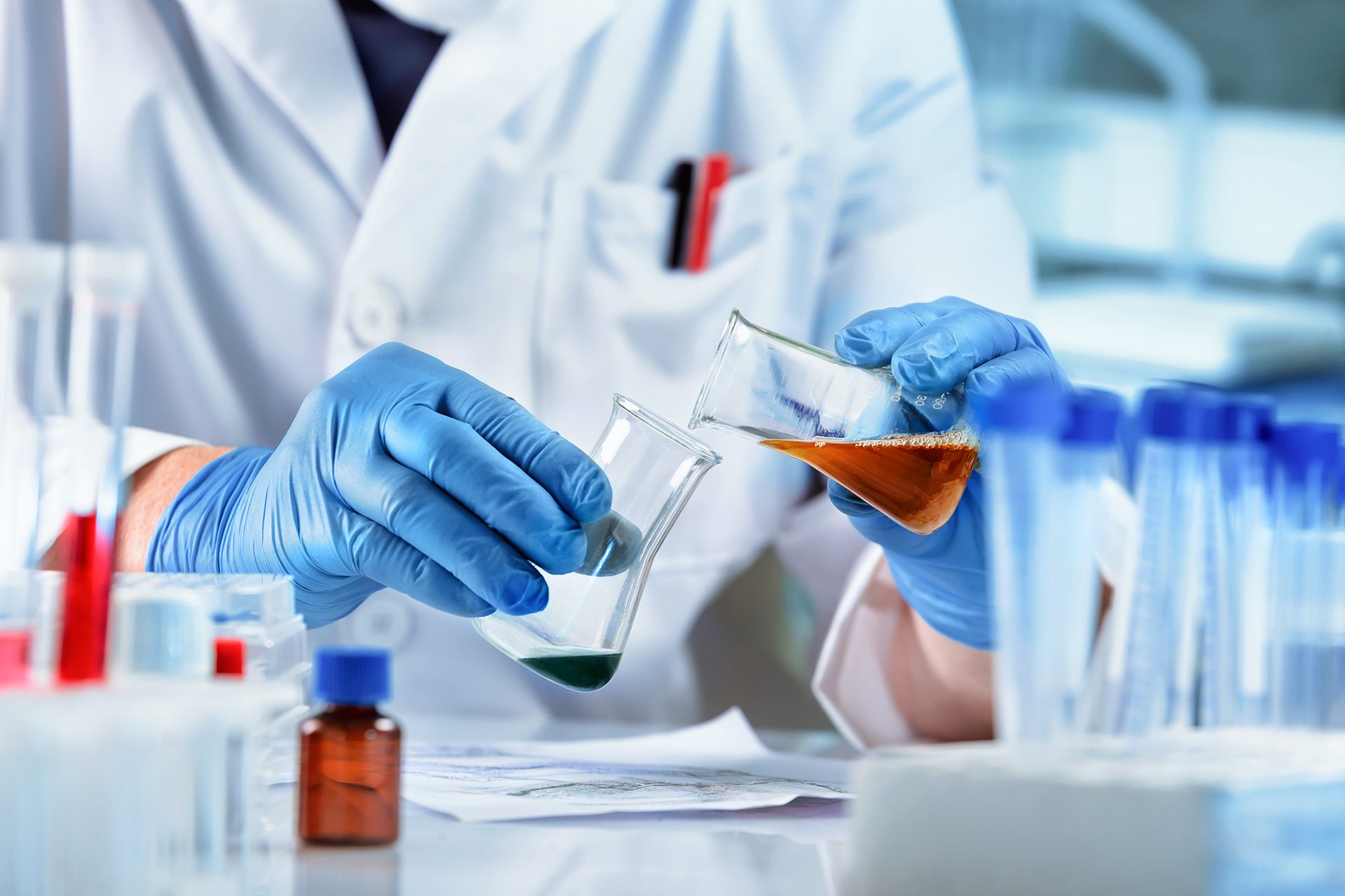 Chemistry lab worker mixing liquids